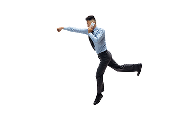 Image showing Man in office clothes practicing taekwondo on white background. Unusual look for businessman in motion, action. Sport, healthy lifestyle.