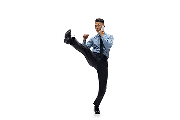 Image showing Man in office clothes practicing taekwondo on white background. Unusual look for businessman in motion, action. Sport, healthy lifestyle.