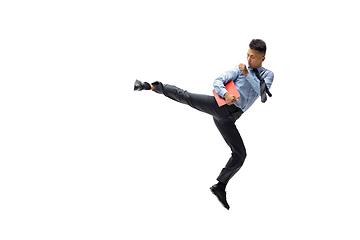 Image showing Man in office clothes practicing taekwondo on white background. Unusual look for businessman in motion, action. Sport, healthy lifestyle.