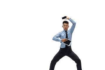 Image showing Man in office clothes practicing taekwondo on white background. Unusual look for businessman in motion, action. Sport, healthy lifestyle.