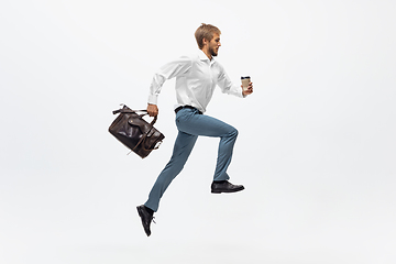 Image showing Man in office clothes running, jogging on white background. Unusual look for businessman in motion, action. Sport, healthy lifestyle.