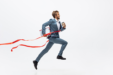 Image showing Man in office clothes running, jogging on white background. Unusual look for businessman in motion, action. Sport, healthy lifestyle.