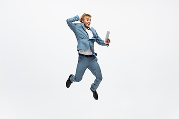 Image showing Man in office clothes running, jogging on white background. Unusual look for businessman in motion, action. Sport, healthy lifestyle.