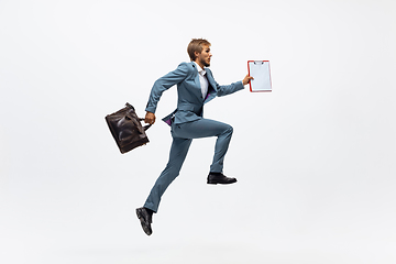 Image showing Man in office clothes running, jogging on white background. Unusual look for businessman in motion, action. Sport, healthy lifestyle.