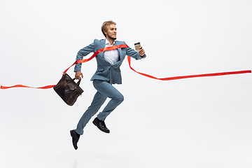 Image showing Man in office clothes running, jogging on white background. Unusual look for businessman in motion, action. Sport, healthy lifestyle.