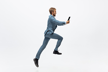 Image showing Man in office clothes running, jogging on white background. Unusual look for businessman in motion, action. Sport, healthy lifestyle.