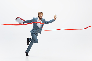 Image showing Man in office clothes running, jogging on white background. Unusual look for businessman in motion, action. Sport, healthy lifestyle.