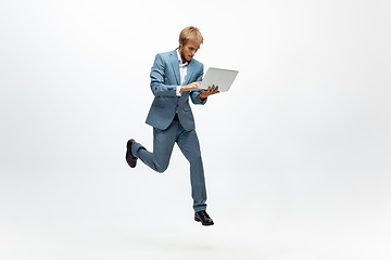 Image showing Man in office clothes running, jogging on white background. Unusual look for businessman in motion, action. Sport, healthy lifestyle.