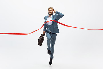 Image showing Man in office clothes running, jogging on white background. Unusual look for businessman in motion, action. Sport, healthy lifestyle.