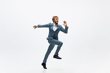 Image showing Man in office clothes running, jogging on white background. Unusual look for businessman in motion, action. Sport, healthy lifestyle.