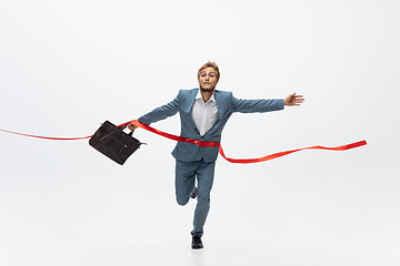 Image showing Man in office clothes running, jogging on white background. Unusual look for businessman in motion, action. Sport, healthy lifestyle.