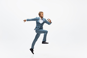 Image showing Man in office clothes running, jogging on white background. Unusual look for businessman in motion, action. Sport, healthy lifestyle.