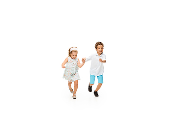 Image showing Happy children, little caucasian boy and girl jumping and running isolated on white background