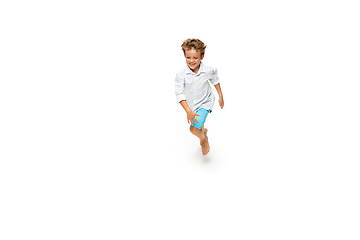 Image showing Happy little caucasian boy jumping and running isolated on white background