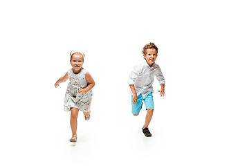 Image showing Happy children, little caucasian boy and girl jumping and running isolated on white background