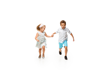 Image showing Happy children, little caucasian boy and girl jumping and running isolated on white background