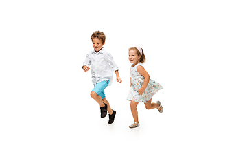 Image showing Happy children, little caucasian boy and girl jumping and running isolated on white background