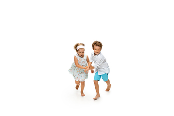 Image showing Happy children, little caucasian boy and girl jumping and running isolated on white background