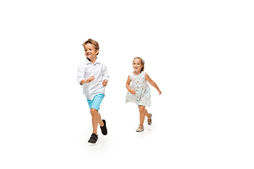 Image showing Happy children, little caucasian boy and girl jumping and running isolated on white background