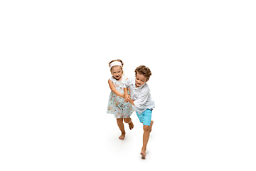 Image showing Happy children, little caucasian boy and girl jumping and running isolated on white background