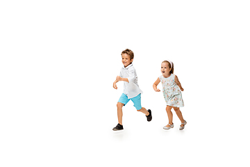 Image showing Happy children, little caucasian boy and girl jumping and running isolated on white background