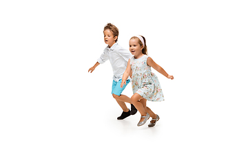 Image showing Happy children, little caucasian boy and girl jumping and running isolated on white background