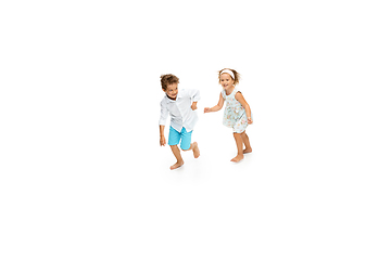 Image showing Happy children, little caucasian boy and girl jumping and running isolated on white background