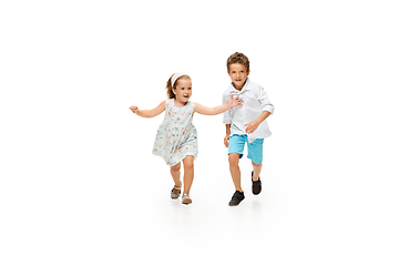 Image showing Happy children, little caucasian boy and girl jumping and running isolated on white background