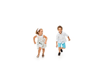 Image showing Happy children, little caucasian boy and girl jumping and running isolated on white background