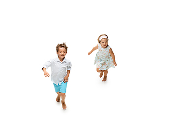 Image showing Happy children, little caucasian boy and girl jumping and running isolated on white background