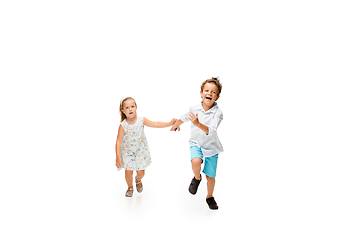 Image showing Happy children, little caucasian boy and girl jumping and running isolated on white background