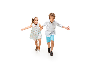 Image showing Happy children, little caucasian boy and girl jumping and running isolated on white background