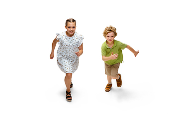 Image showing Happy little caucasian girl and boy jumping and running isolated on white background