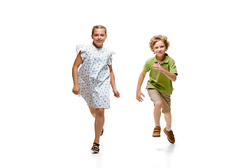 Image showing Happy little caucasian girl and boy jumping and running isolated on white background