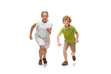 Image showing Happy little caucasian girl and boy jumping and running isolated on white background