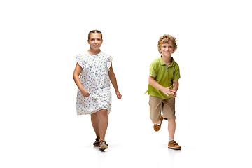 Image showing Happy little caucasian girl and boy jumping and running isolated on white background