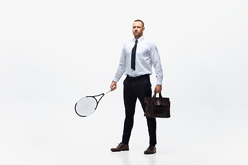 Image showing Time for movement. Man in office clothes plays tennis isolated on white studio background.