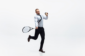 Image showing Time for movement. Man in office clothes plays tennis isolated on white studio background.