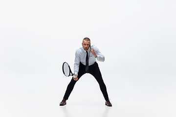 Image showing Time for movement. Man in office clothes plays tennis isolated on white studio background.