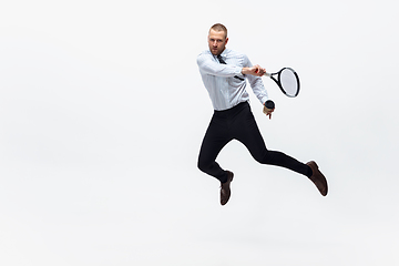 Image showing Time for movement. Man in office clothes plays tennis isolated on white studio background.