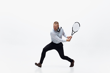 Image showing Time for movement. Man in office clothes plays tennis isolated on white studio background.