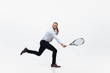 Image showing Time for movement. Man in office clothes plays tennis isolated on white studio background.