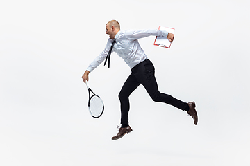 Image showing Time for movement. Man in office clothes plays tennis isolated on white studio background.