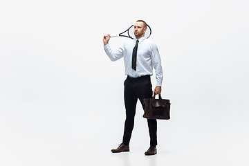 Image showing Time for movement. Man in office clothes plays tennis isolated on white studio background.