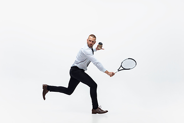 Image showing Time for movement. Man in office clothes plays tennis isolated on white studio background.