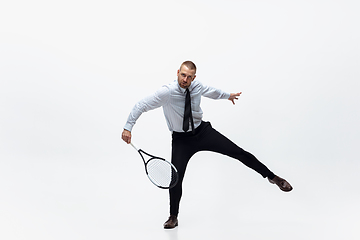 Image showing Time for movement. Man in office clothes plays tennis isolated on white studio background.