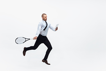 Image showing Time for movement. Man in office clothes plays tennis isolated on white studio background.