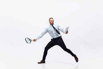 Image showing Time for movement. Man in office clothes plays tennis isolated on white studio background.