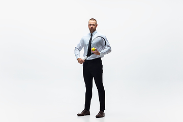 Image showing Time for movement. Man in office clothes plays tennis isolated on white studio background.