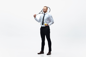 Image showing Time for movement. Man in office clothes plays tennis isolated on white studio background.